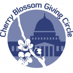 light blue circular Cherry Blossom Giving Circle logo of the Capitol building in dark blue and a white cherry blossom branch spanning across the circle